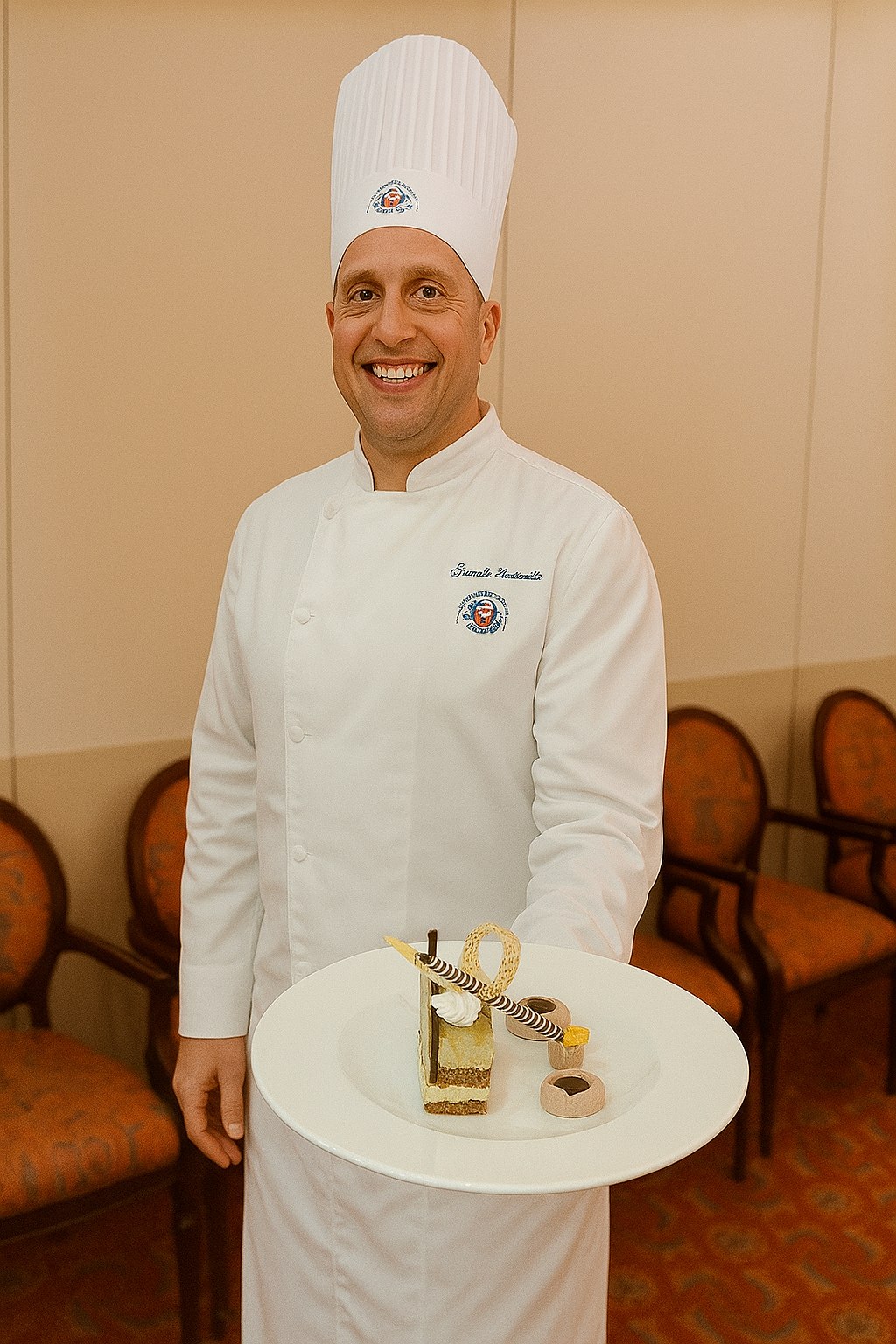 Samuele Zaninotto in giacca da chef con dessert al tavolo